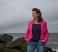 Marion bij de zee met handen in zakken (2)