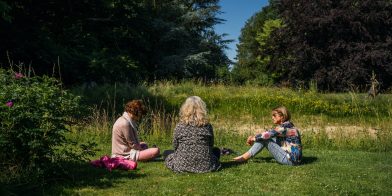 Dames zittend buiten in gras