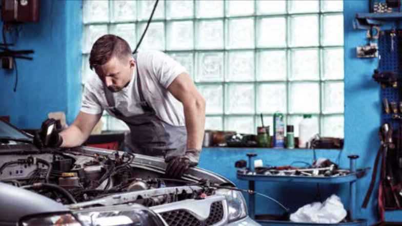 Man sleutelen aan auto