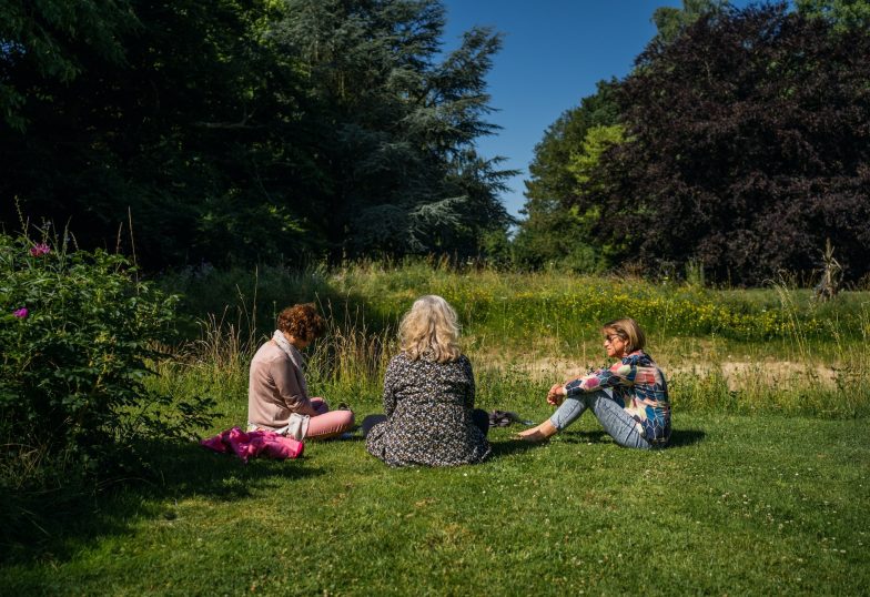 Dames zittend buiten in gras