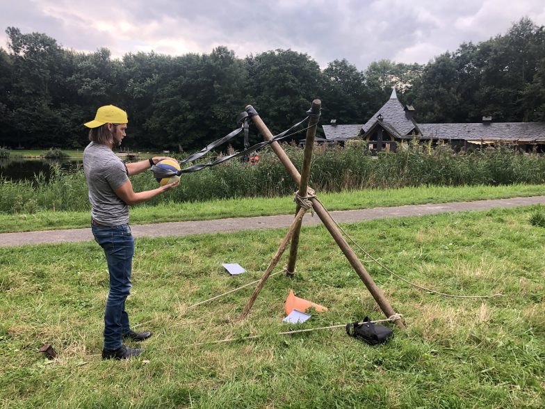 Man gele pet bezig met katapult